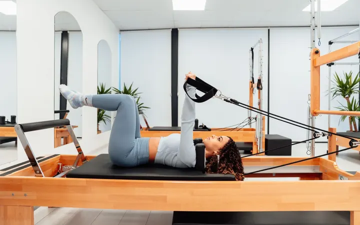 Paciente realizando exercício no reformer de pilates