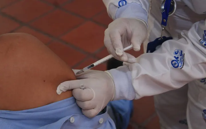 Profissional realizando aplicação injetável no ombro