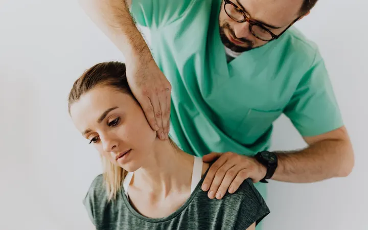Fisioterapeuta realizando ajuste manual na região cervical